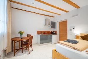 a bedroom with a bed and a table and a kitchen at Gardar Studio Fox in Bolzano