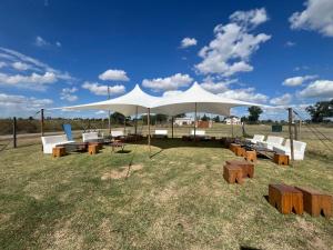a large white tent with benches and tables in a field at Casa Azul Roldan in Roldán