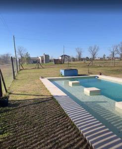 a swimming pool in the middle of a field at Casa Azul Roldan in Roldán