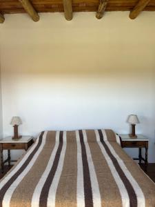 a bed with two lamps on two tables at Casa Azul Roldan in Roldán +11 photos