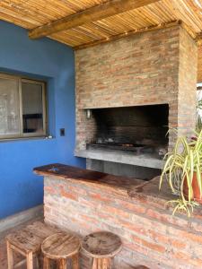 a patio with a brick fireplace with stools at Casa Azul Roldan in Roldán