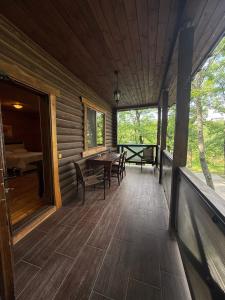 a porch of a log cabin with a table and chairs at База отдыха Дубки in Orlovshchina