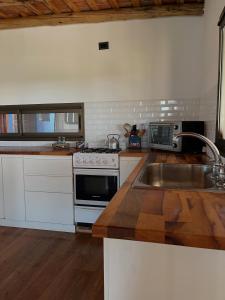 a kitchen with a sink and a stove at Casa Azul Roldan in Roldán