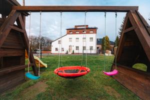 a swing set in a yard with a building at Aparthotel Svitavy in Svitavy
