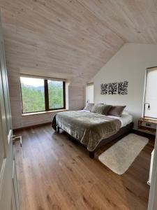 a bedroom with a bed and a large window at Refugio entre Montañas - Malalcahuello in Malalcahuello +128 photos