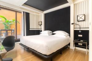 a bedroom with a large white bed and a desk at Europark in Barcelona