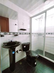 a bathroom with a toilet and a sink and a shower at Bohemia Hotel in Tunja