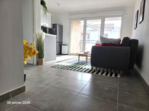 a living room with a couch and a kitchen at Spacieux appartement dans résidence avec piscine in Bormes-les-Mimosas