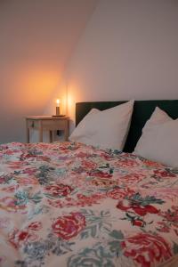 a bedroom with a bed with a floral bedspread at Agroturystyka „Między Polami” in Zalewo