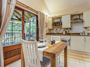 a kitchen with a wooden table and a large window at 1 Bed in Llangammarch Wells oc-bn216 in Garth