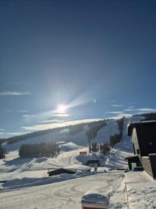 ein schneebedeckter Hang mit der Sonne am Himmel in der Unterkunft Suomunkutsu 2 in Suomutunturi + 3 Fotos