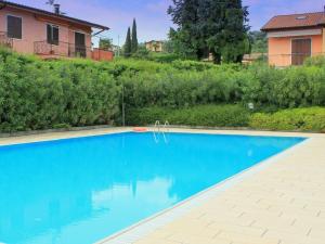een blauw zwembad voor een huis bij Belvilla by OYO Bardolino Ventitre in Bardolino