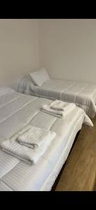 two beds with white sheets and towels on them at LOFTb , EN EL CORAZON DE SALTA in Salta