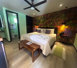 a bedroom with a bed with a ceiling fan and a table at Parti Gras Hotel & Villas en Playa Potrero in Potrero