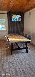 a wooden table and chairs in a room at Vila Two in Cârțișoara