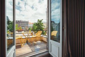 a balcony with a table and chairs on a balcony at The Originals Boutique, Hôtel Le Lion, Clermont-Ferrand in Clermont-Ferrand