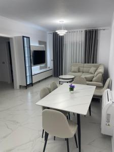 a living room with a white table and a couch at Lux apartment in Kamëz