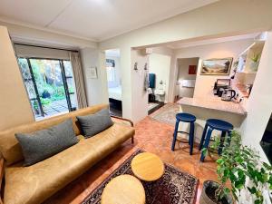 a living room with a couch and a kitchen at Oatlands Cottages in Grahamstown