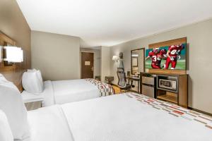 a hotel room with two beds and a flat screen tv at Red Roof Inn Lumberton in Lumberton