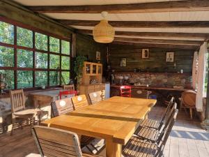 a dining room with a wooden table and chairs at Agroturystyka „Między Polami” in Zalewo