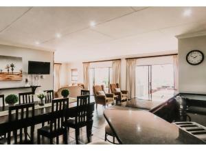 a living room with a table and chairs and a clock at Aloe Corner, Cathkin Estates by Euphoric Leisure in Ardmore
