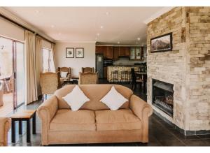 a living room with a couch and a fireplace at Aloe Corner, Cathkin Estates by Euphoric Leisure in Ardmore
