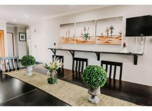 a dining room with a table and a tv at Aloe Corner, Cathkin Estates by Euphoric Leisure in Ardmore +8 photos