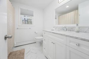 a white bathroom with a toilet and a sink at Hidden Gem Lake House 3BR, 2.5BA in Holbrook +26 photos