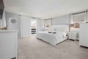 a white bedroom with a white bed and windows at Hidden Gem Lake House 3BR, 2.5BA in Holbrook