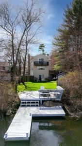 a house with a dock next to a body of water at Hidden Gem Lake House 3BR, 2.5BA in Holbrook