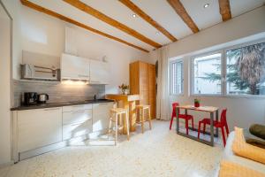 a kitchen with white cabinets and a table and chairs at Gardar in Bolzano