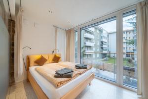 a bedroom with a bed and a large window at Gardar in Bolzano