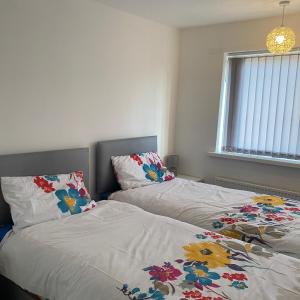 two beds sitting next to each other in a bedroom at Robin's Accommodation in Wythenshawe