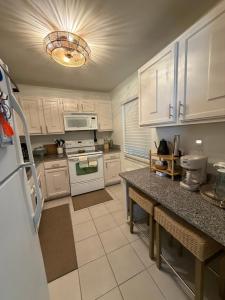 eine Küche mit weißen Schränken und einer Arbeitsplatte in der Unterkunft Relaxing 1bd 1ba Condo - Ocean Front Complex in New Smyrna Beach in New Smyrna Beach