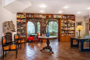 a living room with a table and bookshelves at L'Elisea Maison De Charme in Castellabate +61 photos