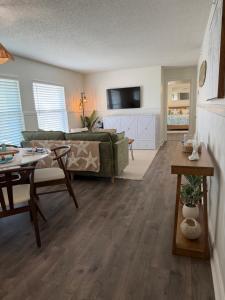 ein Wohnzimmer mit Sofa und Tisch in der Unterkunft Relaxing 1bd 1ba Condo - Ocean Front Complex in New Smyrna Beach in New Smyrna Beach