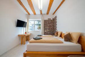 two beds in a room with a brick wall at Gardar in Bolzano