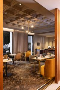 a dining room with tables and yellow chairs at Le Tsuba Hotel in Paris +43 photos