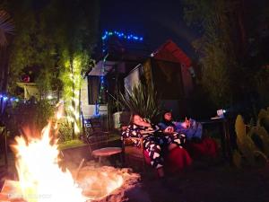 a group of people sitting around a fire at night at Killa Glamping in Sangolquí