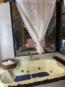 a bath tub in a bathroom with a window at Killa Glamping in Sangolquí +8 photos