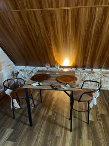 a table with two wine glasses and two chairs at Killa Glamping in Sangolquí