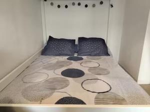 a bed in a white room with at Studio proche océan dans résidence 3 étoiles avec piscine et parking privé in Mimizan-Plage +16 photos