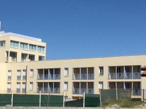 an apartment building with balconies and a fence at Studio proche océan dans résidence 3 étoiles avec piscine et parking privé in Mimizan-Plage