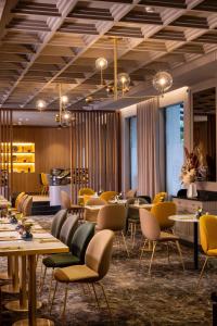 a restaurant with tables and chairs in a room at Le Tsuba Hotel in Paris
