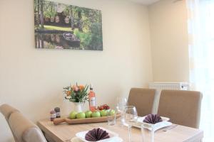 a dining room table with apples and wine glasses at Quartier Spreestraße - App 2 in Burg