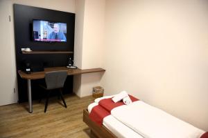 a room with a bed and a desk with a television at Brauerei Walter in Waldshut-Tiengen