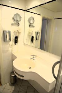 a bathroom with a white sink and a mirror at Brauerei Walter in Waldshut-Tiengen +14 photos