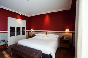 a bedroom with a large white bed and red walls at Hotel 1898 in Barcelona