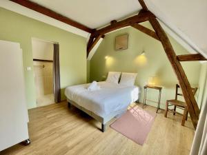 a bedroom with a large white bed and a bathroom at Les Sibylles in Châtellerault