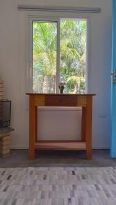 a large window in a room with a wooden table at Pousada Águas do Alto in São Francisco Xavier